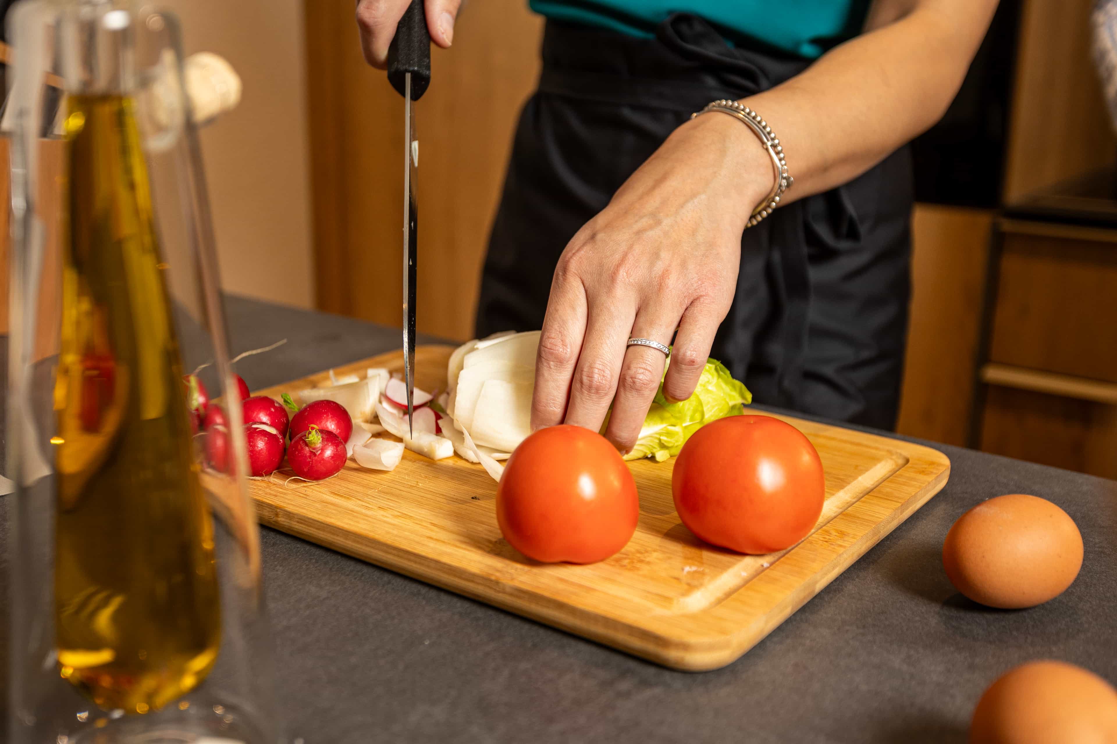 Eine Frau bereitet eine Mahlzeit in ihrem Apartment bei La Maison Suisse Döttingen